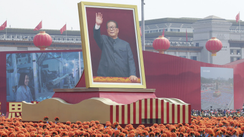 Ciudadanos caminan por la avenida Changan con una carroza que muestra al ex presidente chino Jiang Zemin. REUTERS / Jason Lee