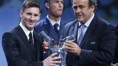 El delantero argentino del FC Barcelona, Lionel Messi, recibe el premio al mejor jugador de Europa de la UEFA de manos del presidente de la UEFA, Michel Platini. EFE/Guillaume Horcajuelo