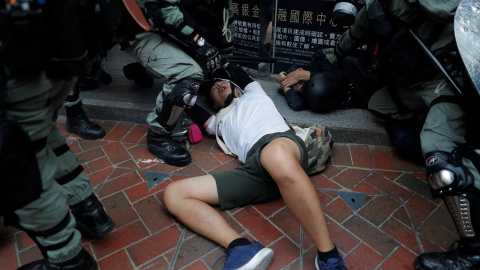 La policía antidisturbios detiene a un manifestante antigubernamental durante una manifestación en el distrito de Wan Chai. REUTERS / Susana Vera