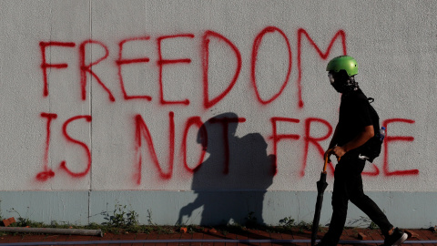 Un manifestante antigubernamental camina frente al graffiti durante una protesta en el distrito de Sha Tin, en el Día Nacional de China en Hong Kong, China, el 1 de octubre de 2019. REUTERS / Jorge Silva