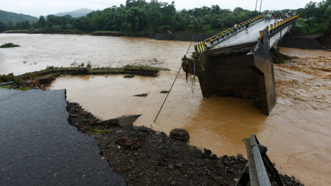 Locals look into a damaged bridge after floods hit Manuju in Gowa, South Sulawesi, Indonesia, January 23, 2019 in this photo taken by Antara Foto. Picture taken January 23, 2019. Antara Foto/Yusran Uccang/ via REUTERS ATTENTION EDITORS - TH