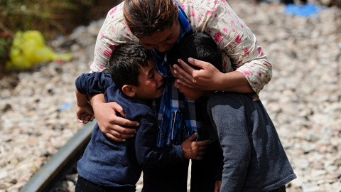 Una mujer abraza a dos niños después de cruzar la frontera de Grecia a Macedonia.- OGNEN TEOFILOVSKI (REUTERS)