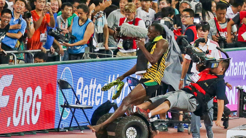 Usain Bolt es derribado por un cámara de televisión que perdió el control de su Segway. El accidente tuvo lugar después de que el jamaicano ganara la final de los 200 metros durante los campeonatos del mundo de atletismo en Pekín (China).- 