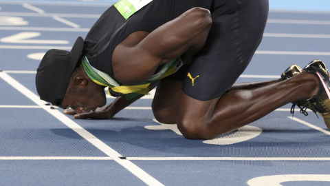 El atleta jamaicano Usain Bolt besa la pista tras ganar en Rio su novena medalla de oro en unos JJOO. REUTERS/Phil Noble