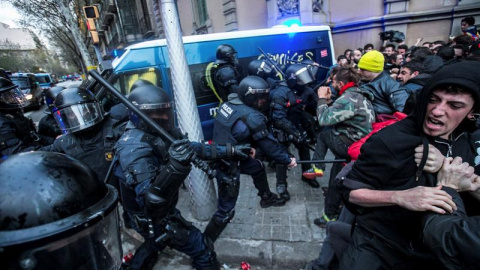 Miembros de los Mossos d´Esquadra impiden el paso de manifestantes en las inmediaciones de la Delegación del Gobierno en Cataluña, donde centenares de independentistas tratan de desbordar el cordón policial en protesta por la detención del 