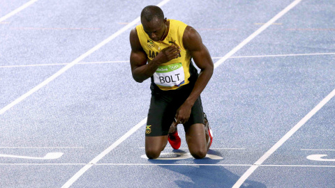 Usain Bolt, arrodillado, tras ganar la medalla de oro en los 200 metros. REUTERS/David Gray