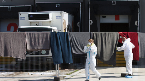 Miembros del equipo forense caminan frente al camión donde fueron encontrados los cadáveres de 70 refugiados, en la la localidad de  Nickelsdorf, Austria.