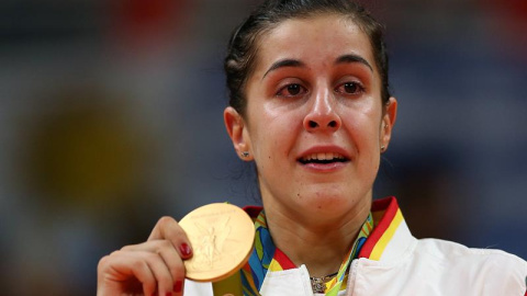 Carolina Marín sujeta la medalla de oro con los ojos enjugados en lágrimas. /EFE