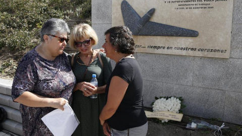 Familiares de los fallecidos lloran ante el lugar en el que se hace la ofrenda de flores en Madrid por el accidente de Spanair/EFE