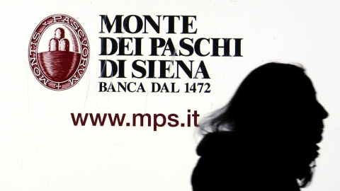 Una mujer pasa por delante de un anuncio del banco Monte dei Paschi di Siena en el centro de Milán. REUTERS/Stefano Rellandini