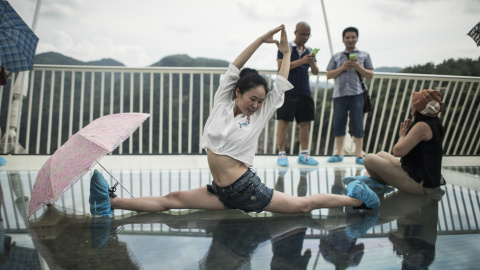 Una mujer posa acrobáticamente  en el puente. FRED DUFOUR / AFP