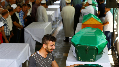 Un familiar de una de las víctimas del atentado en la ciudad turca de Gaziantep junto a los ataudes de los fallecidos. REUTERS/Osman Orsal