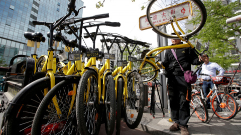 Un miembro del personal de la compañía de bicicletas compartidas Ofo, una de las múltiples de 'startup' que han proliferado rápidamente, reúne sus bicicletas compartidas para usar durante la hora punta de la tarde, en Beijing, China. Al ten