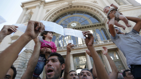 Cientos de inmigrantes protestan y muestran sus billetes a las puertas de la estación de Keleti, en Budapest. REUTERS