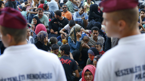 Cientos de inmigrantes custodiados por la policía esperan a las afueras de la estación de Keleti, en Budapest. REUTERS