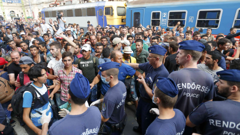 Cientos de refugiados protestan ante la policía, que les impide acceder a los trenes para viajar a otros países de Europa. REUTERS