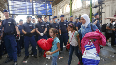 Los refugiados abandonan la estación ante las órdenes de las autoridades, que impiden que suban a los trenes. REUTERS