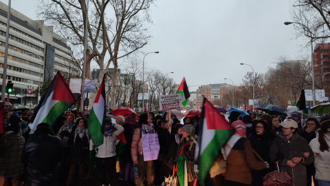 Un grupo de manifestantes se refugia de la lluvia en la protesta contra el genocidio en Gaza ante la sede en Madrid de la Comisión Europea, a 02/03/2024.