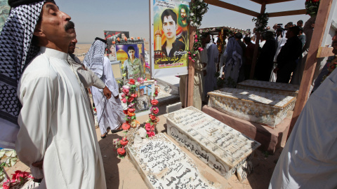 Unos iraquíes visitan las tumbas de sus parientes en el cementerio de Wadi al-Salam (el 'Valle de la Paz), en Nayaf, al sur de Bagdad. REUTERS / Alaa Al-Marjani