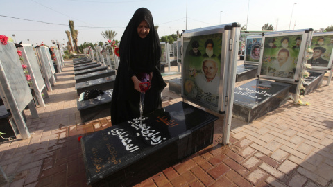 Una mujer lava la tumba de un familiar en el cementerio de Wadi al-Salam (el 'Valle de la Paz', en árabe), en Nayaf, al sur de Bagdad. REUTERS / Alaa Al-Marjani