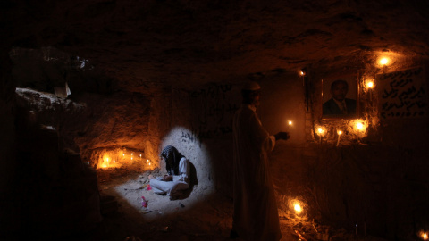 Un hombre lee versos del Corán en la tumba de un familiar en el cementerio de Wadi al-Salam (en árabe 'Valle de la Paz'), en Nayaf, al sur de Bagdad. REUTERS / Alaa Al-Marjani