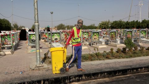 Un trabajador municipal con un contenedor de basura en el cementerio de Wadi al-Salam (que en árabe significa 'Valle de la Paz'), en Nayaf, al sur de Bagdad. REUTERS / Alaa Al-Marjani