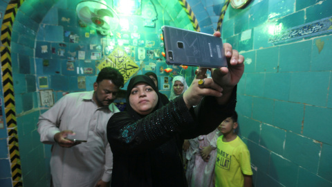 Una mujer toma un selfie en el interior del santuario del Imam Mahdi en el cementerio de Wadi al-Salam (el 'Valle de la Paz'), en Nayaf, al sur de Bagdad. REUTERS / Alaa Al-Marjani