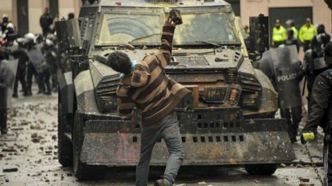 Un manifestante lanza una piedra a un vehículo blindado de la Policía en Quito./ Rodrigo Buendía (AFP)