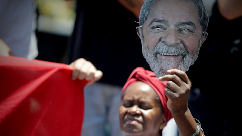 Una mujer sostiene una imagen del expresidente brasileño Luiz Inácio Lula da Silva, durante el entierro de su hermano mayor, Genival Inácio da Silva, conocido como Vavá, en el cementerio de Sao Bernardo do Campo (Brasil). EFE/Fernando Bizer