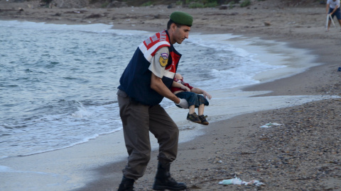 Un agente de la gendarmería turca lleva el cuerpo de un niño que formaba parte del grupo de refugiados sirios que se han ahogado intentando llegar a la isla de Kos. REUTERS/Nilufer Demir