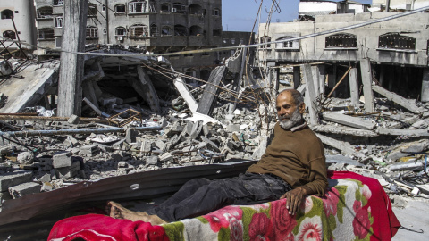 Un hombre tumbado sobre los escombros tras los ataques israelíes.