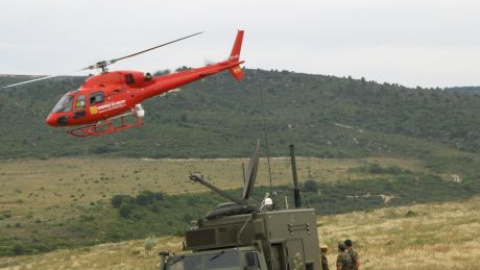 Un grupo de soldados observa cómo un helicóptero del servicio de emergencias del Gobierno de Aragón sobrevuela una zona con riesgo de incendio./Aragonhoy.net