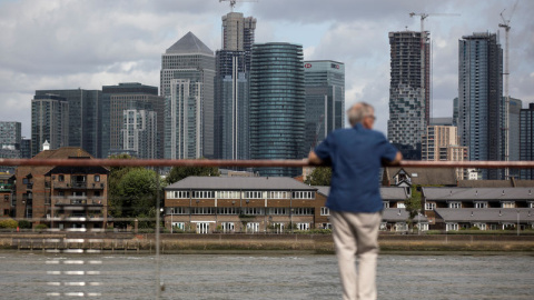 Un hombre mira hacia el distrito financiero de Canary Wharf en Londres. REUTERS/Simon Dawson