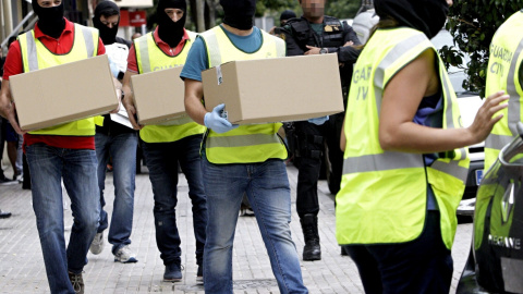 Agentes de la Guardia Civil trasladan el material incautado en la vivienda de la joven de 18 años de origen marroquí que ha sido detenida en Gandía (Valencia) por su presunta relación con actividades del terrorismo yihadista. EFE/Rubén Fran