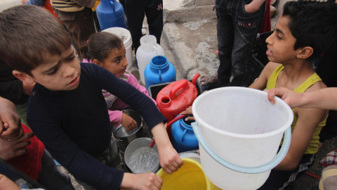 Unos niños esperan que para recoger agua potable en la ciudad siria de Alepo. REUTERS/Giath Taha