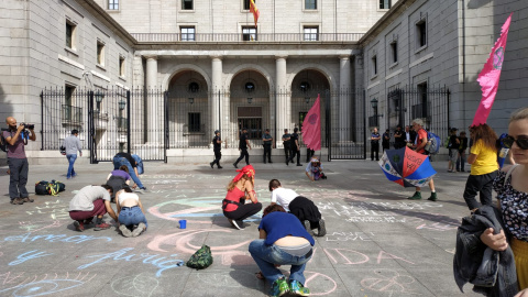 Algunos activistas han pintado con tiza mensajes reivindicativos frente a la entrada del Ministerio para la Transición Ecológica. | Foto: G. M. M.