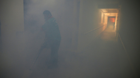 Un trabajador en el pasillo nublado de un parque de vivienda pública donde se descubrió un caso de virus Zika, en Singapur. REUTERS/Edgar Su