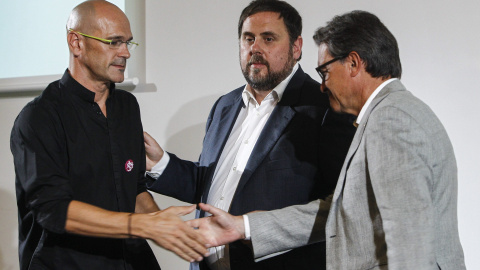 El candidato numero 1 de Junts pel Sí, Raul Romeva, saluda al president de la Generalitat y candidato numero 4, Artur Mas, en presencia del candidato numero 5, Oriol Junqueras, durante el acto de presentación del programa electoral de la co