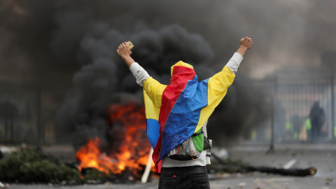 Un manifestante cubierto con una bandera ecuatoriana se para frente a una barricada durante una protesta contra las medidas de austeridad del presidente de Ecuador, Lenin Moreno, en Quito, Ecuador, 8 de octubre de 2019. REUTERS / Ivan Alvar