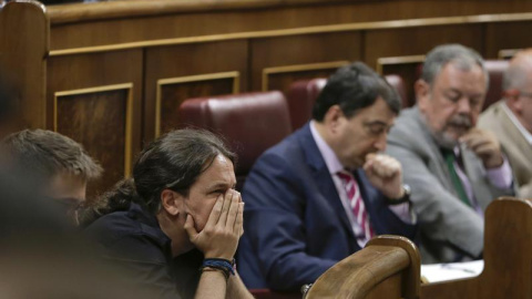 El secretario general de Podemos, Pablo Iglesias (i), escucha hoy desde su escaño el discurso de investidura del presidente en funciones, Mariano Rajoy. EFE/Emilio Naranjo