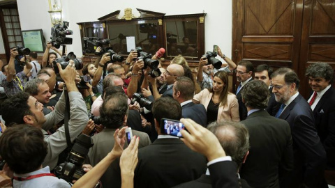 El presidente del Gobierno en funciones, Mariano Rajoy (2d), ante los medios gráficos en el pasillo del Congreso de los Diputados, tras abandonar el hemiciclo después de pronunciar esta tarde su discurso de investidura. EFE/Emilio Naranjo