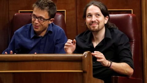 Íñigo Errejón y Pablo Iglesias, integrantes de Podemos, reaccionan ante el discurso del presidente del Gobierno en funciones, Mariano Rajoy, durante la sesión de investidura. REUTERS/Juan Medina