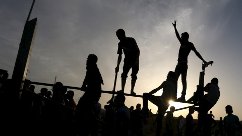 Manifestantes palestinos se sitúan en la valla fronteriza durante los enfrentamientos con las tropas israelíes cerca de la frontera entre Israel y el centro de la Franja de Gaza 13 de octubre de 2015. REUTERS / Ibraheem Abu Mustafa