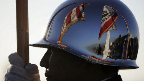 Las banderas de EEUU y del estado de California se reflejan en el casco de un estudiante de secundaria de Hollywood durante la ceremonia de apertura del Observatorio Griffith, el 2 de noviembre de 2006 en Los Ángeles.