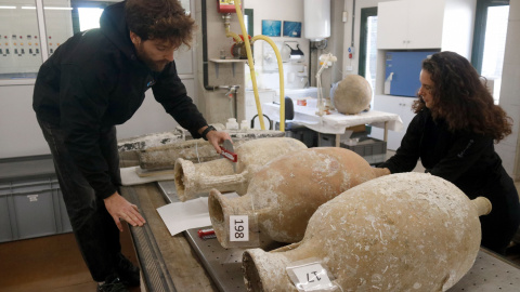 Dos arqueòlegs del CASC estudiant les àmfores que transportava el vaixell romà del segle I aC enfonsat a les illes Formigues