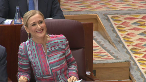 La presidenta de la Comunidad de Madrid, Cristina Cifuentes, ríe desde su escaño tras un comentario del portavoz del grupo Ciudadanos, Ignacio Aguado.