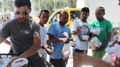 Un vigilante griego reparte comida entre los refugiados de Kara-Tepé, en la isla de Lesbos. - TOMÁS PARRA