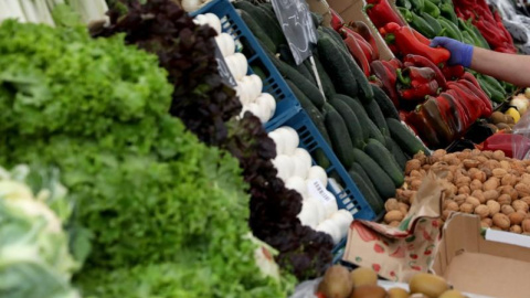 Un vendedor recoge un pimiento rojo en una verdulería en un mercado de Madrid. REUTERS/Sergio Pérez