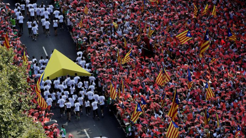 Los porteadores del puntero amarillo se dirigen hacia donde tendrán lugar los parlamentos y actuaciones. EFE/Alberto Estévez