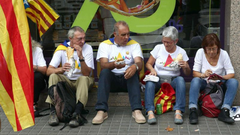 Un grupo de manifestantes come unos bocadillos en la Meridiana de Barcelona donde esta tarde se celebrará la manifestación con motivo de la Diada. EFE/Toni Albirr